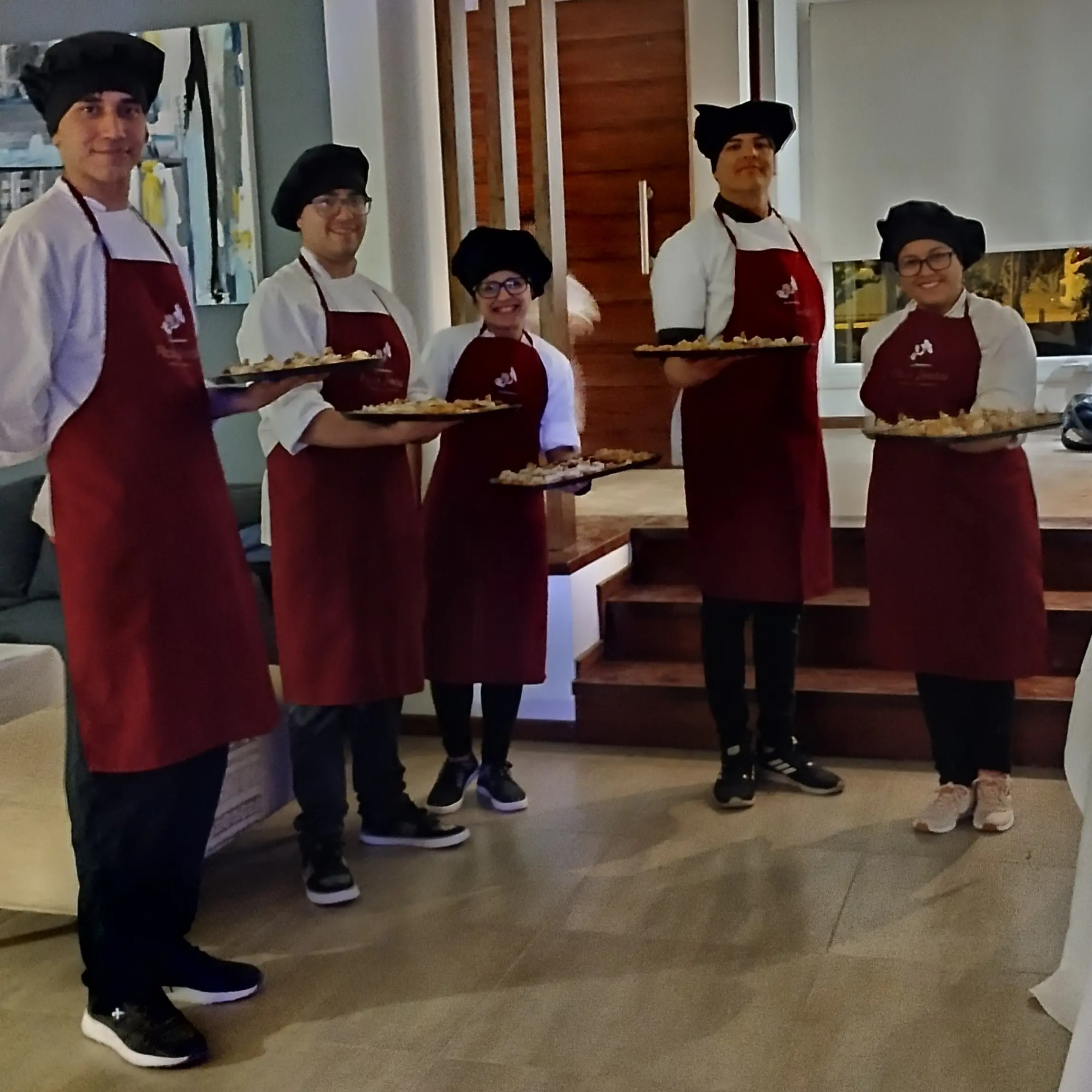 Mozos sirviendo pizza a la parrilla en evento en Córdoba